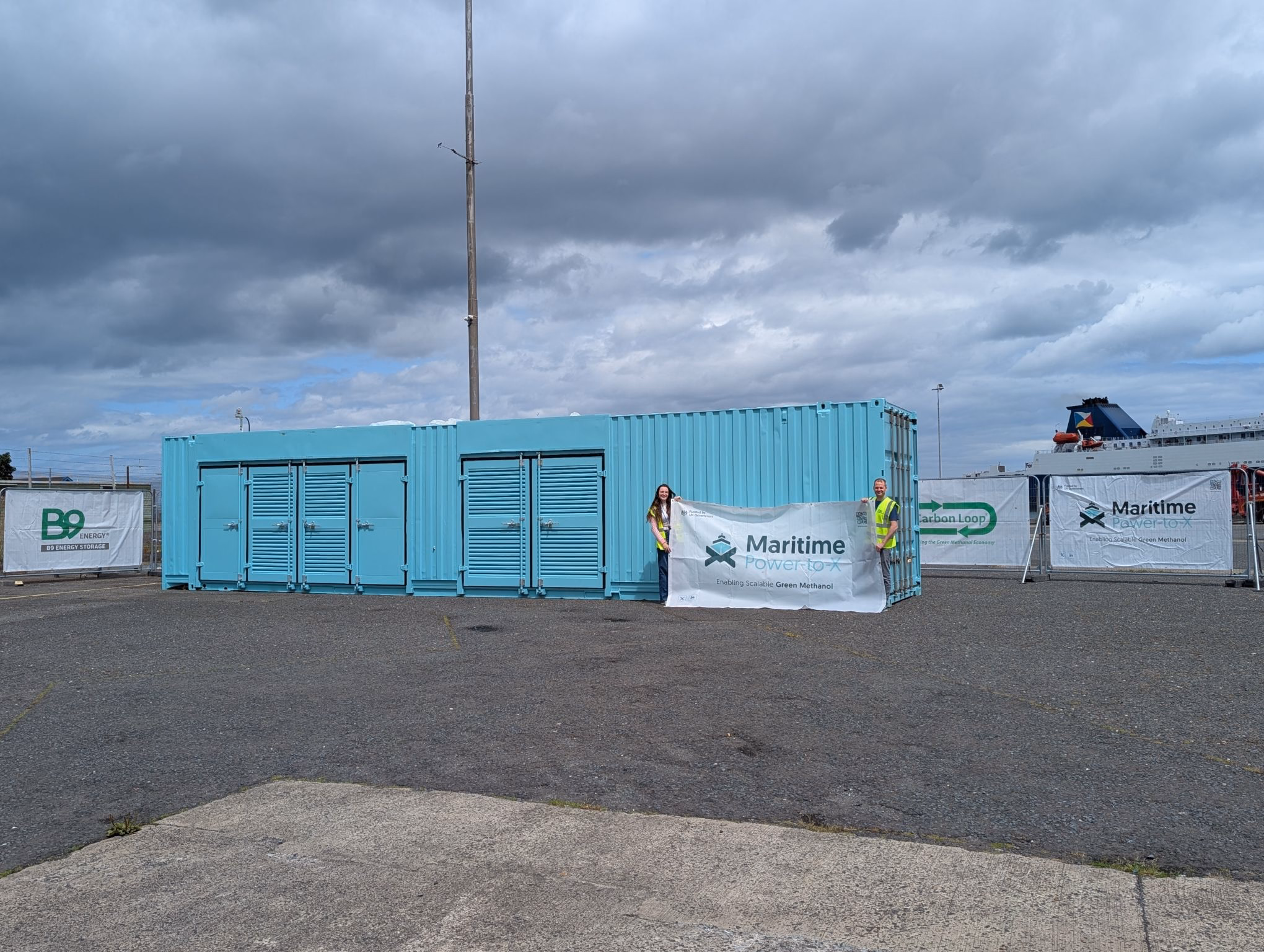 A blue container unit at Larne Harbour with Maritime Power-to-X banners
